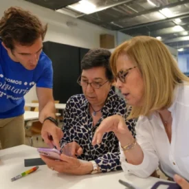 Tres personas utilizan un smartphone en un momento de Reconectados