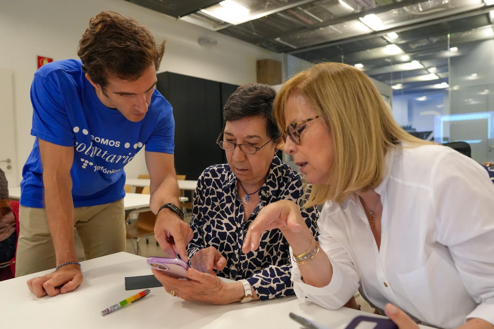 Tres personas utilizan un smartphone en un momento de Reconectados
