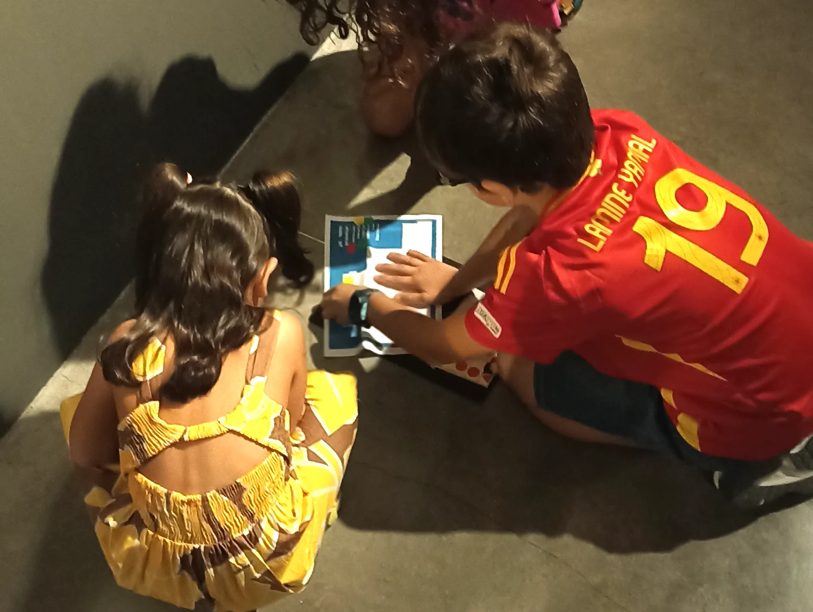 Tres niños juegan en el suelo durante el taller de fotografía de Robert Frank