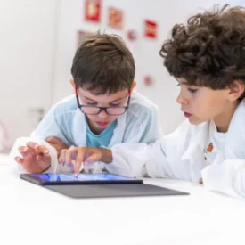 Dos niños dibujan y programan en una tableta en un taller de cuántica