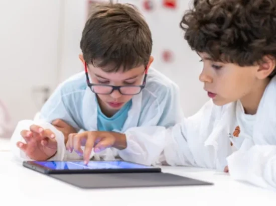 Dos niños dibujan y programan en una tableta en un taller de cuántica