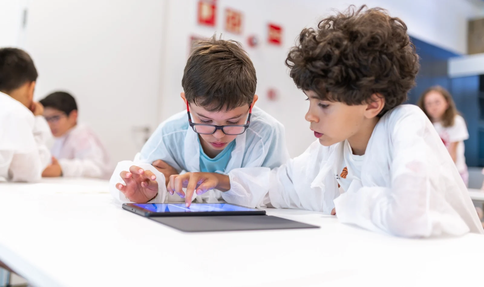 Dos niños dibujan y programan en una tableta en un taller de cuántica | Espacio Fundación Telefónica Dos niños dibujan y programan en una tableta en un taller de cuántica