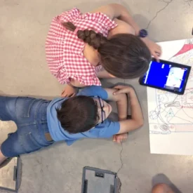 Un niño y una niña dibujan y programan en una tableta en un taller de cuántica