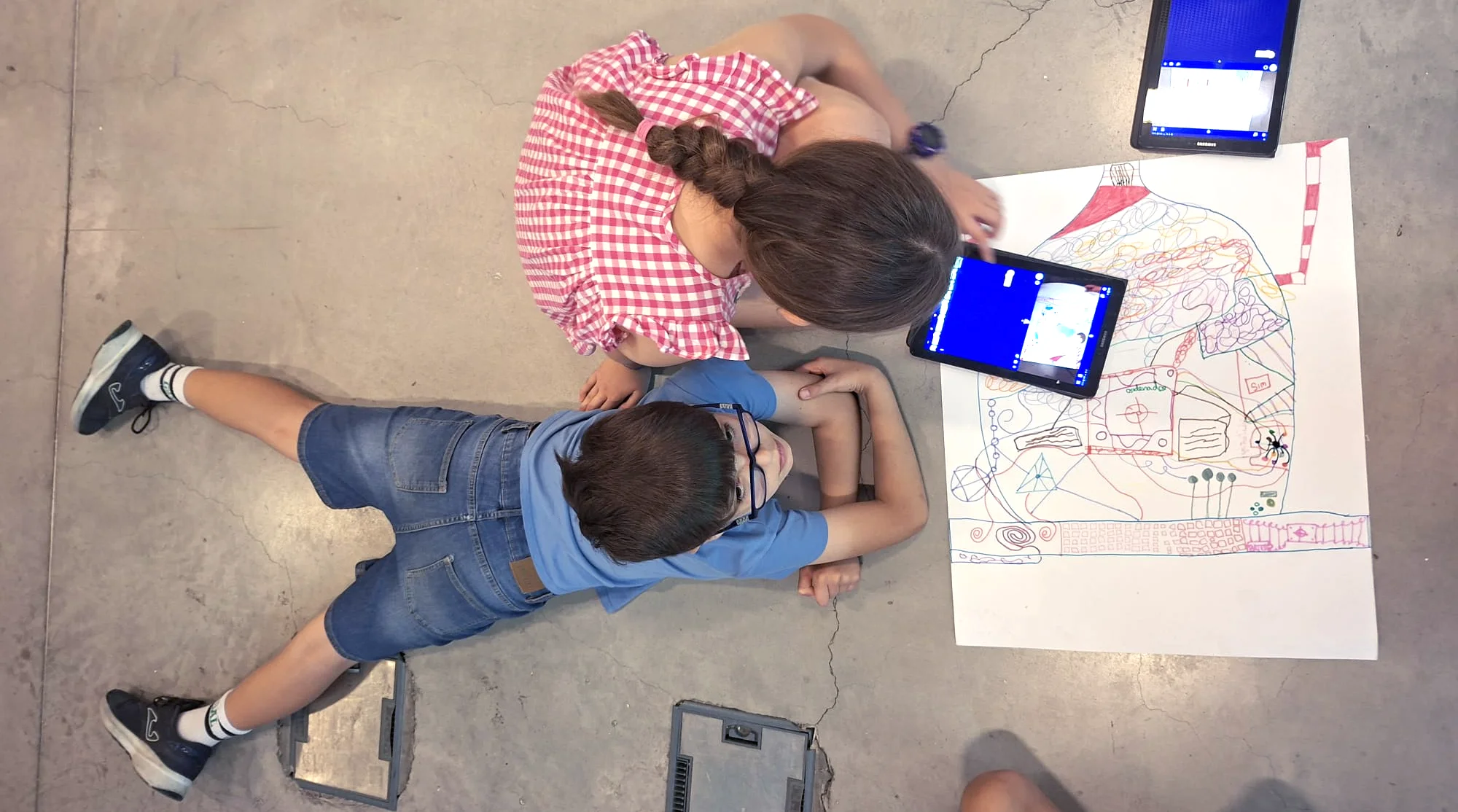 Un niño y una niña dibujan y programan en una tableta en un taller de cuántica