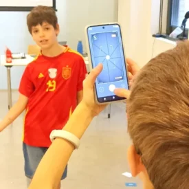 Dos niños experimentan con la cámara de un móvil en un taller de fotografía
