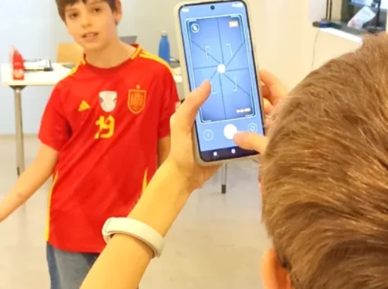 Dos niños experimentan con la cámara de un móvil en un taller de fotografía