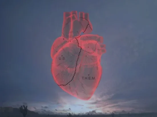 Un corazón humano dividido por una línea fronteriza flota sobre el desierto. Imagen nocturna.